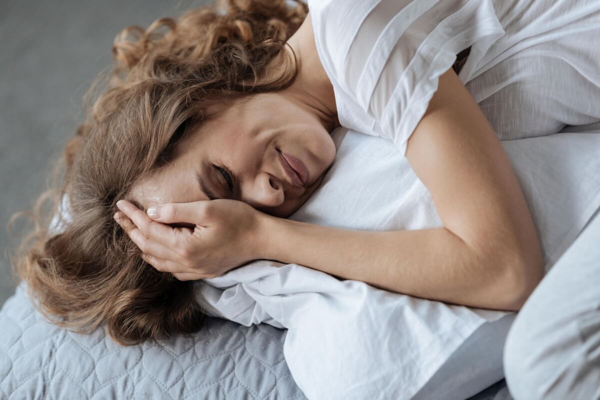 Женщина плачет в подушку